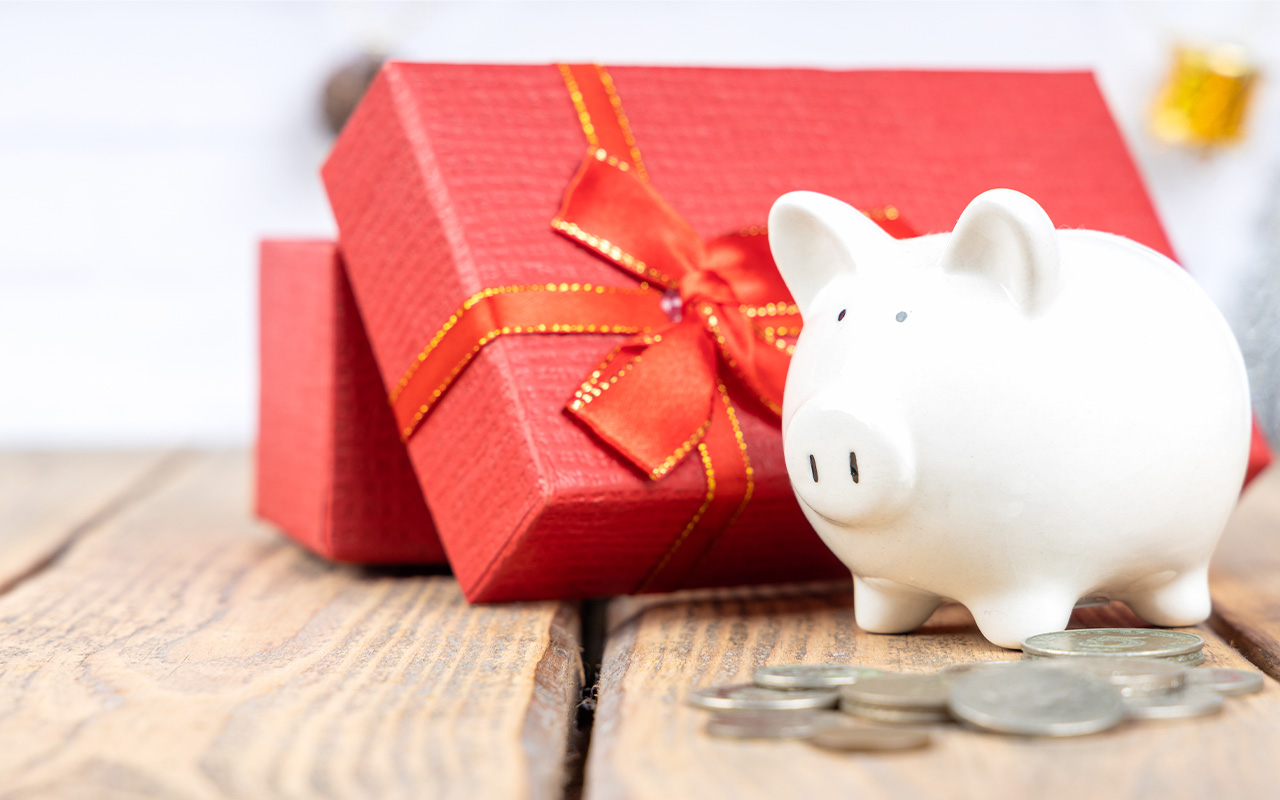 A piggy bank in front of a holiday present