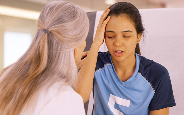 girl wearing a sports jersey holding her head