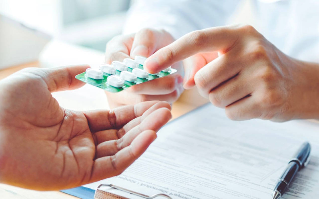 Pharmacist handing medication to a patient