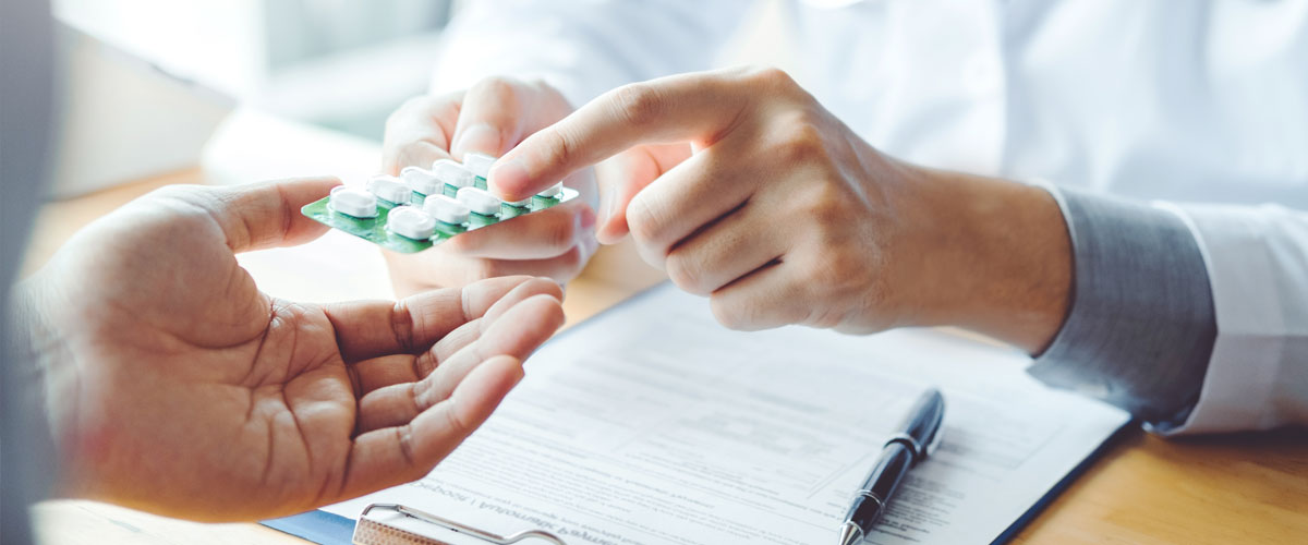 Pharmacist handing medication to a patient