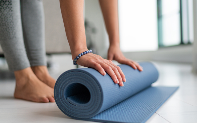 Woman rolling up yoga mat