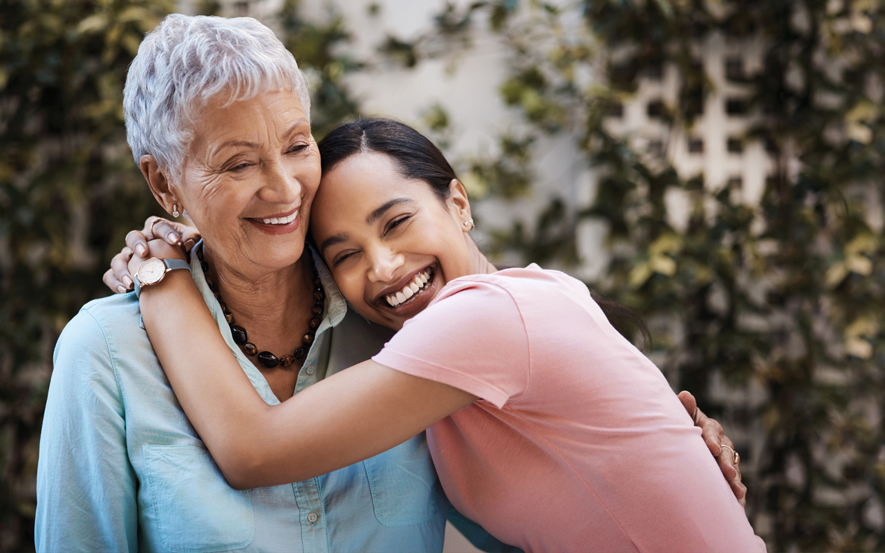 Grandmother and adult grandchild hugging