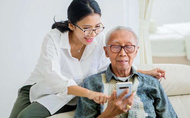 Daughter helping her father with technology