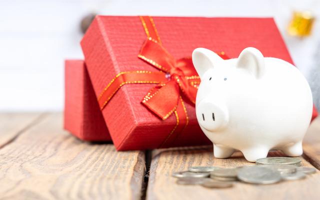 A piggy bank in front of a holiday present