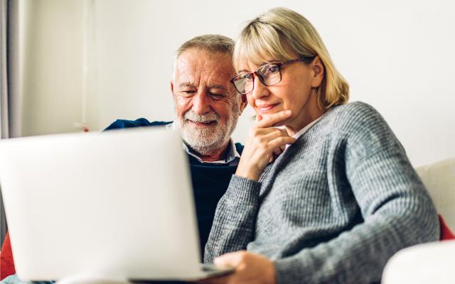 Two adults reviewing information on a laptop 