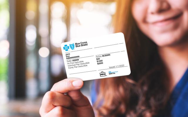 Woman holding a Blue Cross & Blue Shield of RI member ID card