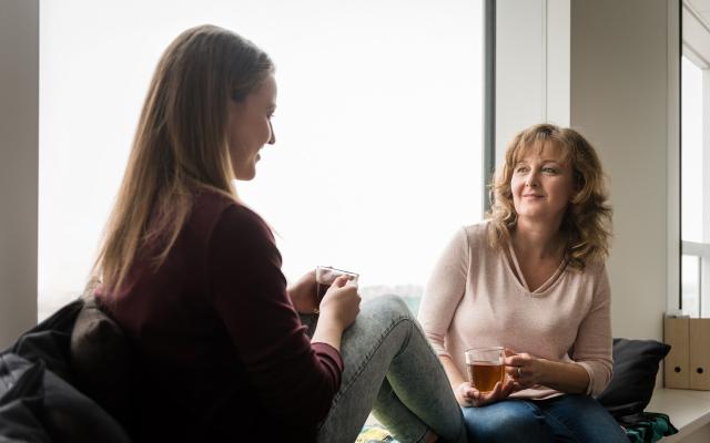 Daughter and mom talking in front of a window