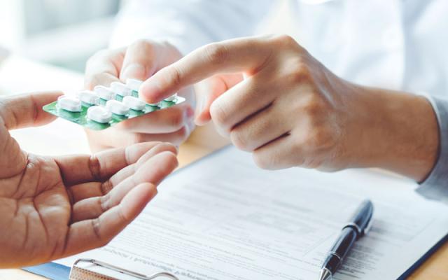 Pharmacist handing medication to a patient