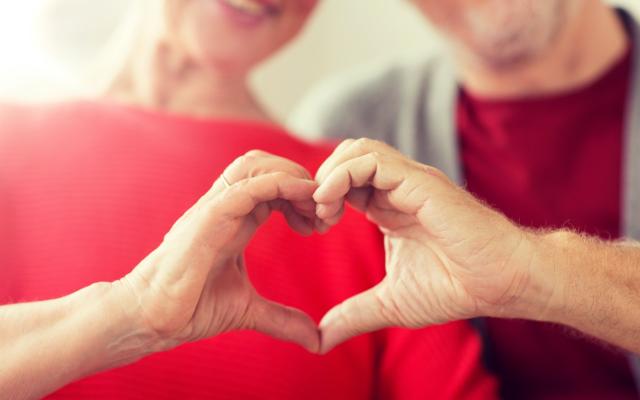 Couple making heart with their hands